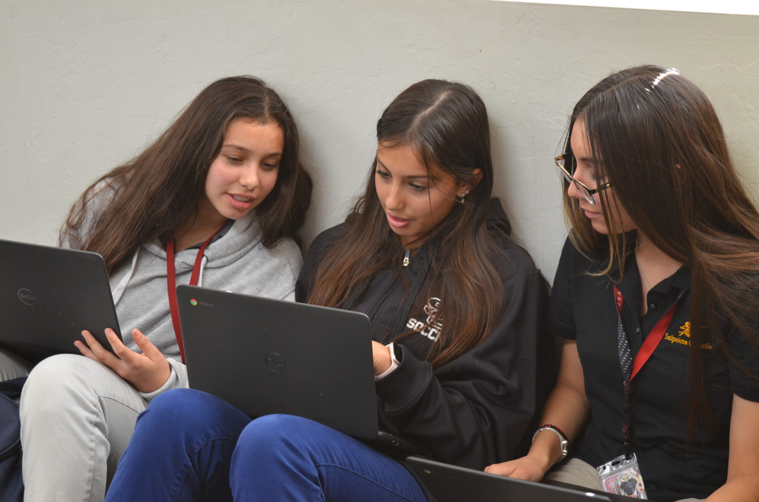 Students gathered around a laptop